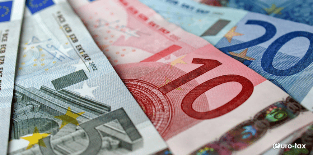 Bancnote euro reprezentând veniturile obținute în străinătate și posibilele obligații fiscale din România.